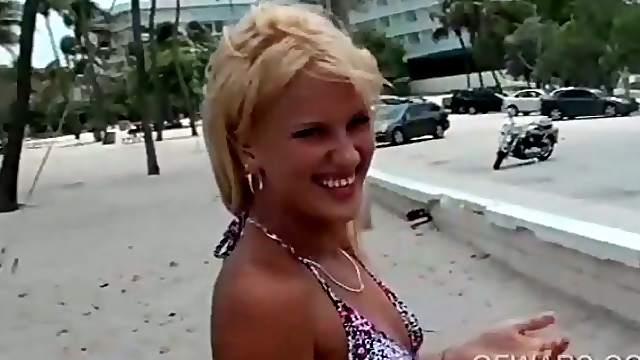 Beach blonde shows her pierced pink cunt in close-up