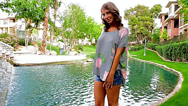 Playful babe in blue jeans shorts flashing her tits in public
