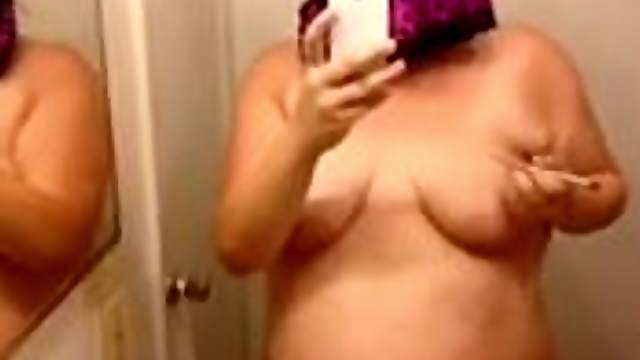 Chubby amateur brunette writes on her big tits in front of a mirror