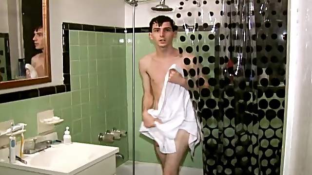 Skinny gay guy with short dark hair playing with his massive cock on his sofa