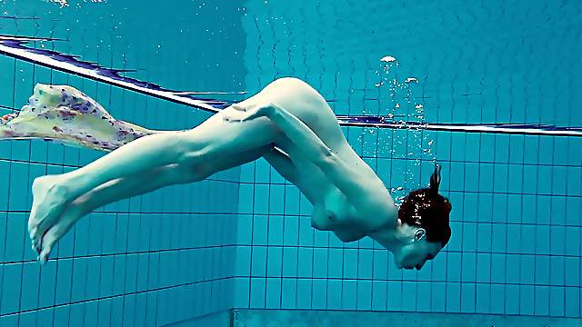Ravishing redhead babe with a nice ass strips down underwater