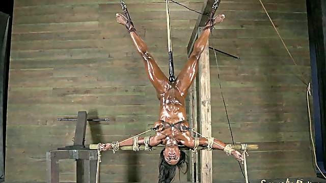 Crucified ebony slave drilled with toy yelling in BDSM porn