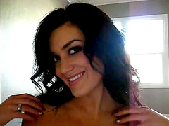 Long-haired brunette Carmen James strips slowly in front of a cam